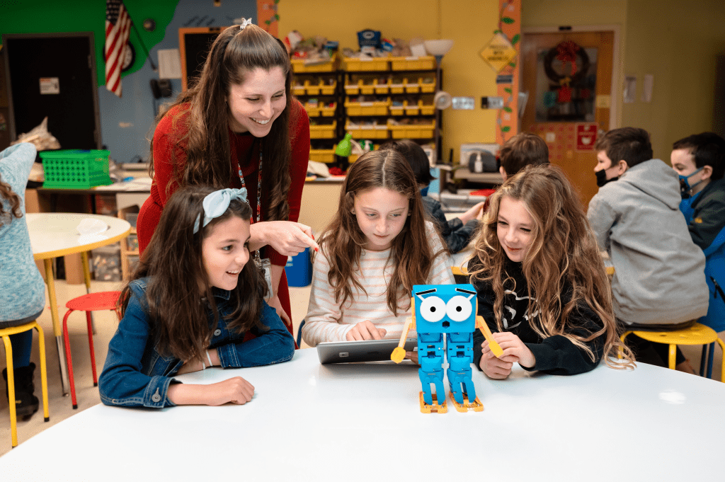 Three students learning to code from Marty the Robot