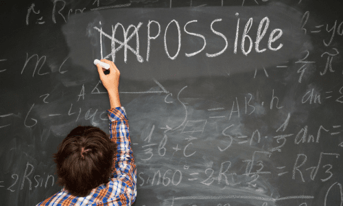 Child changing the word impossible to possible on blackboard