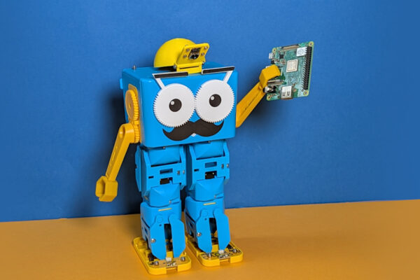 Marty the Robot with a camera hat, holding a Raspberry Pi